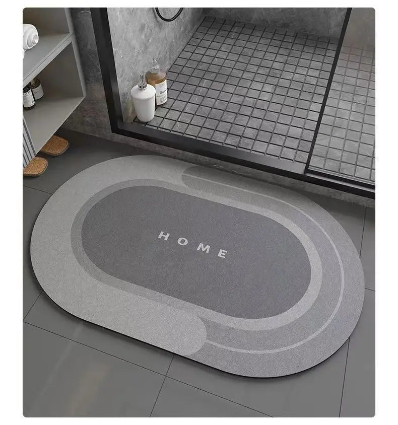 A gray bath mat with a non-slip rubber base is placed on a tiled floor in a bathroom setting.