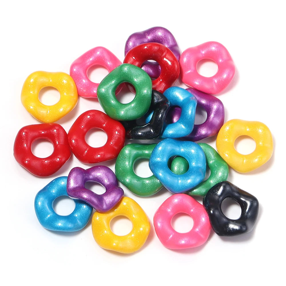 A collection of colorful acrylic spacer beads in various shades including pink, purple, green, yellow, and red.