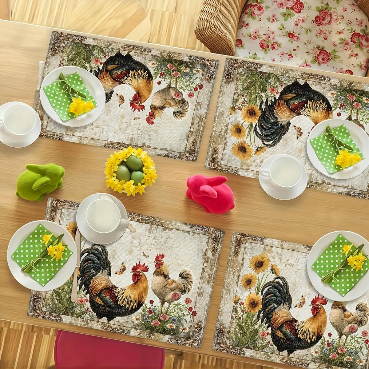 A set of four vintage farmhouse rooster and daisy placemats on a wooden table with white cups.