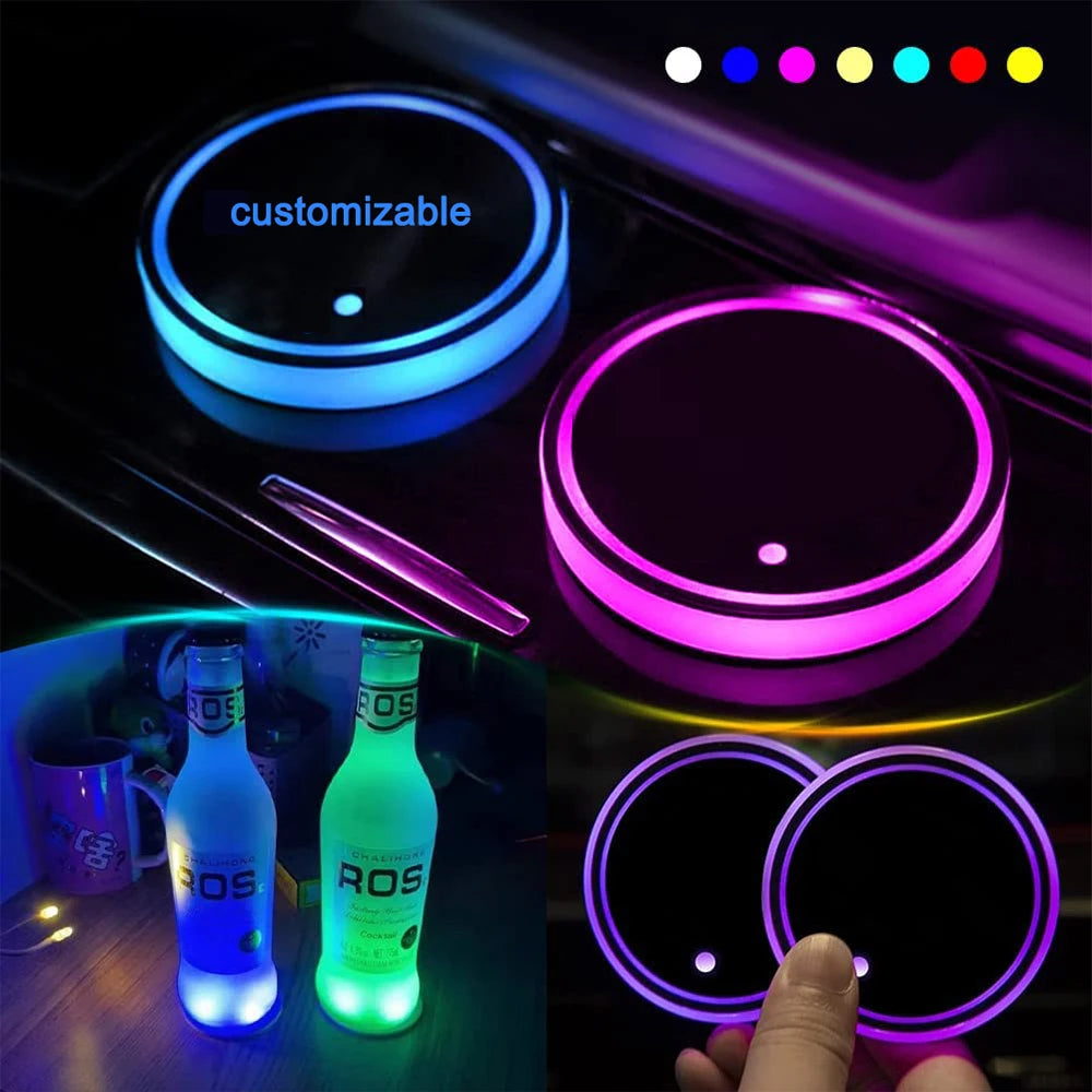 A hand holds a set of customizable LED cup holder lights with various colors illuminating the interior of a car.