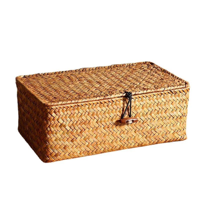 A rectangular woven rattan storage basket with a lid, made of natural brown fibers.