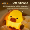 A hand is holding a yellow silicone Highland cattle night light with a timer, illuminating the animal.
