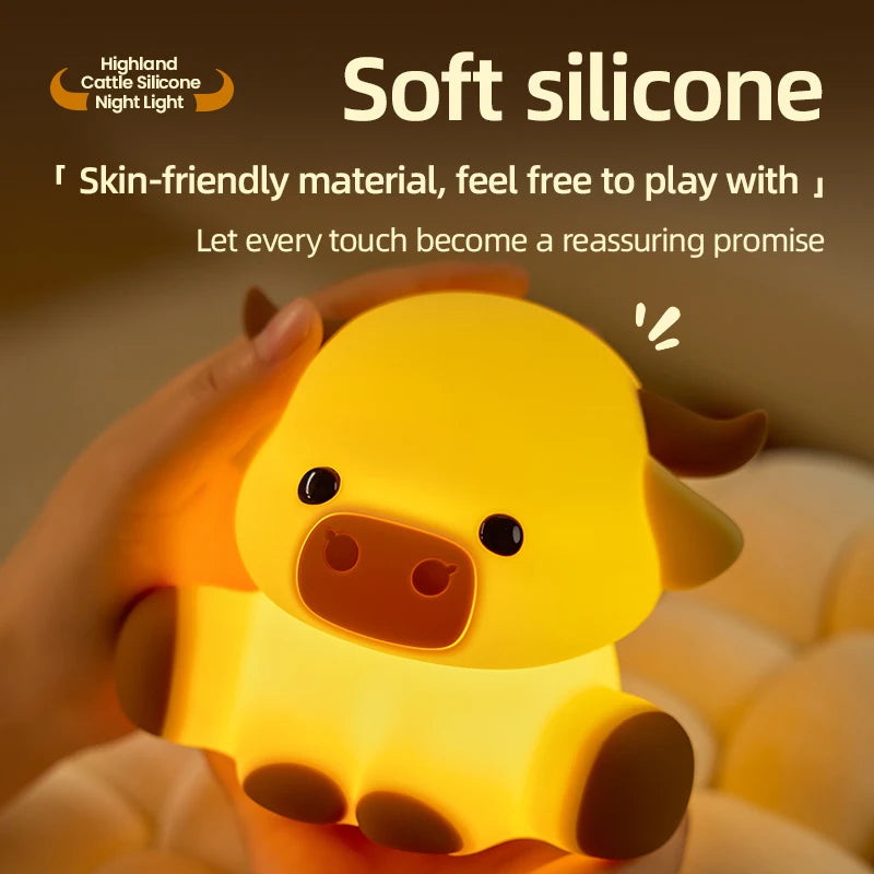 A hand is holding a yellow silicone Highland cattle night light with a timer, illuminating the animal.