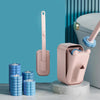 A pink wall-mounted disposable toilet brush set with a replaceable head is displayed next to a toilet.