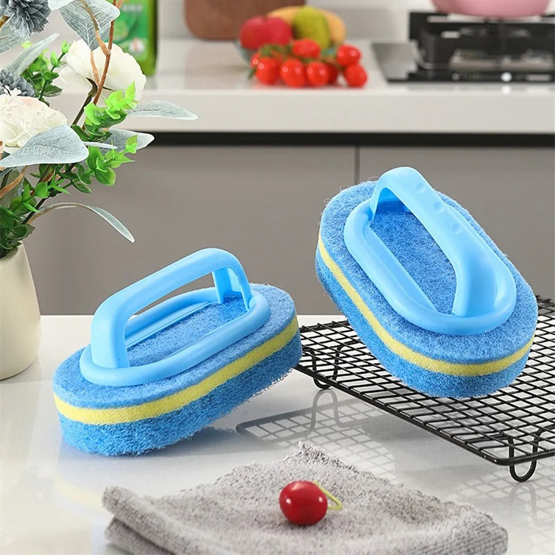 A bright blue sponge cleaning brush with a handle rests on a black wire rack next to a gray towel and a red fruit.