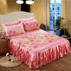 Jupe de lit à motifs floraux roses recouvrant un lit avec tête de lit blanche et rideaux transparents.