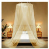 A romantic canopy mosquito net draped over a double bed with bedside lamps.