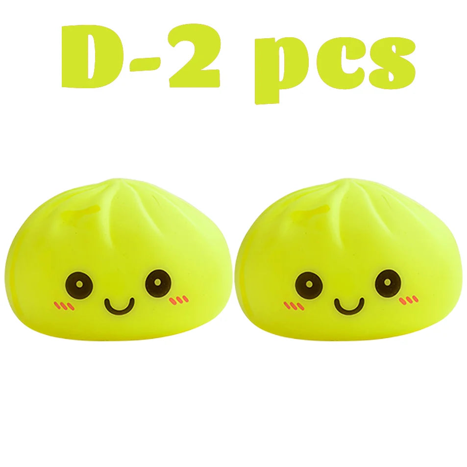 Dos juguetes blandos amarillos brillantes con forma de dumplings sonrientes.