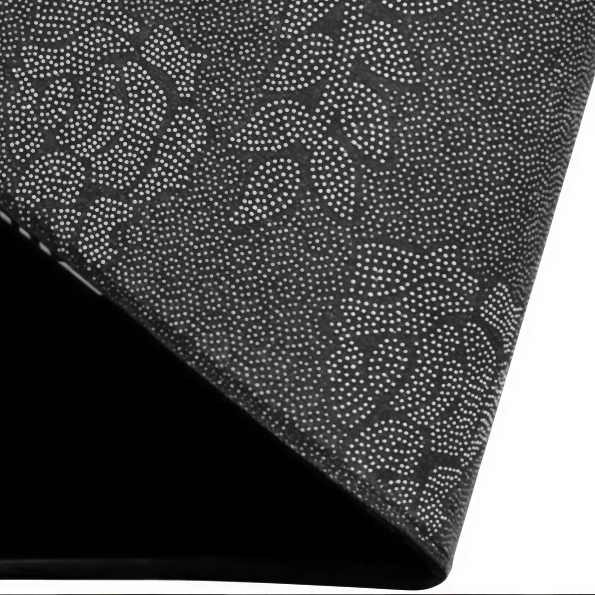 Close-up view of a black doormat with a speckled pattern, shown at an angle.