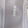 A gray bath mat with the word HOME printed on it, featuring a non-slip rubber base.