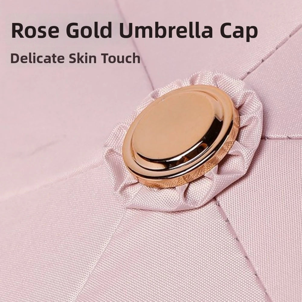 A rose gold umbrella cap resting on pink fabric.