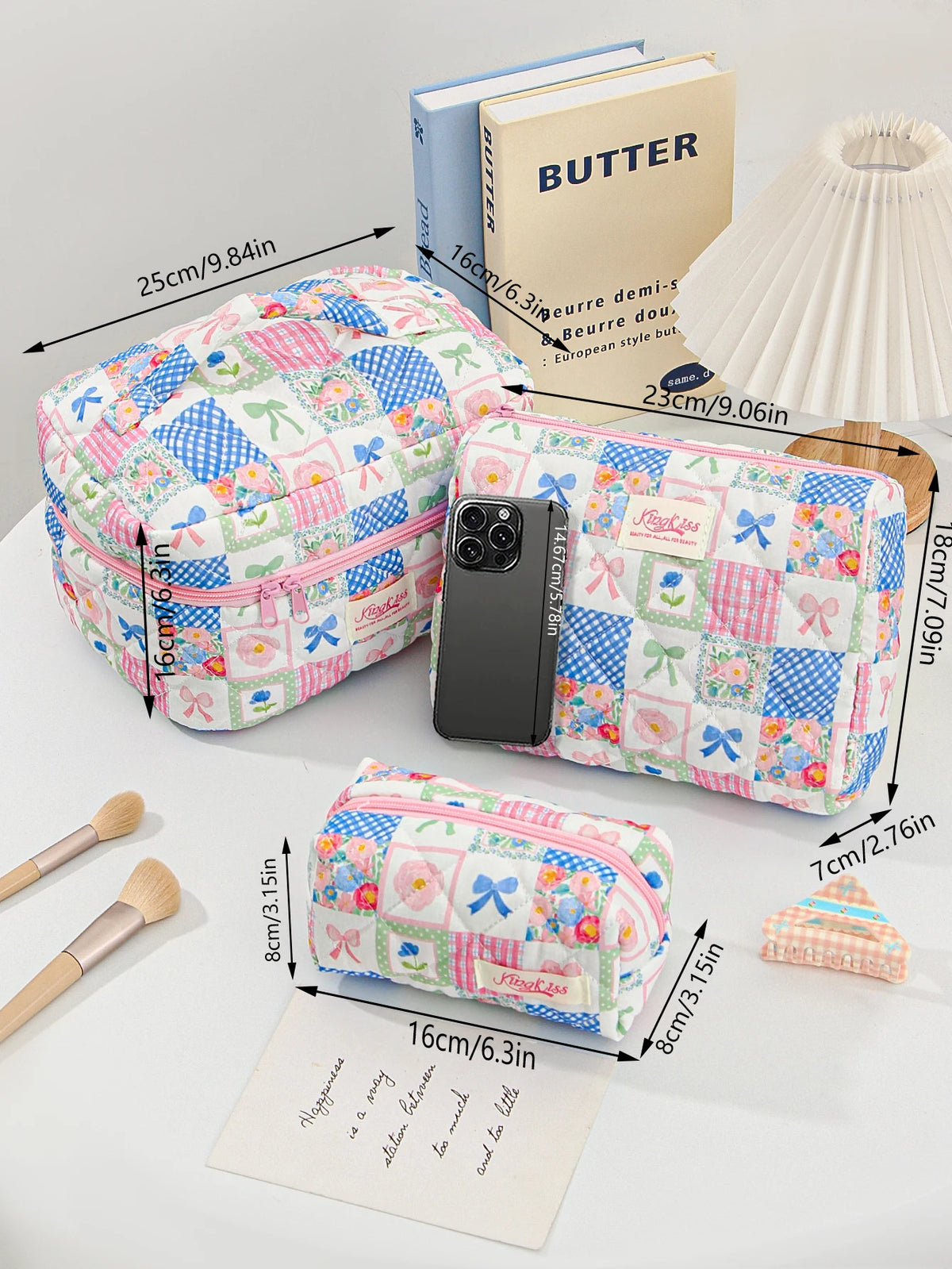 A collection of colorful patchwork quilted makeup bags and a butter-colored book are displayed on a white surface.