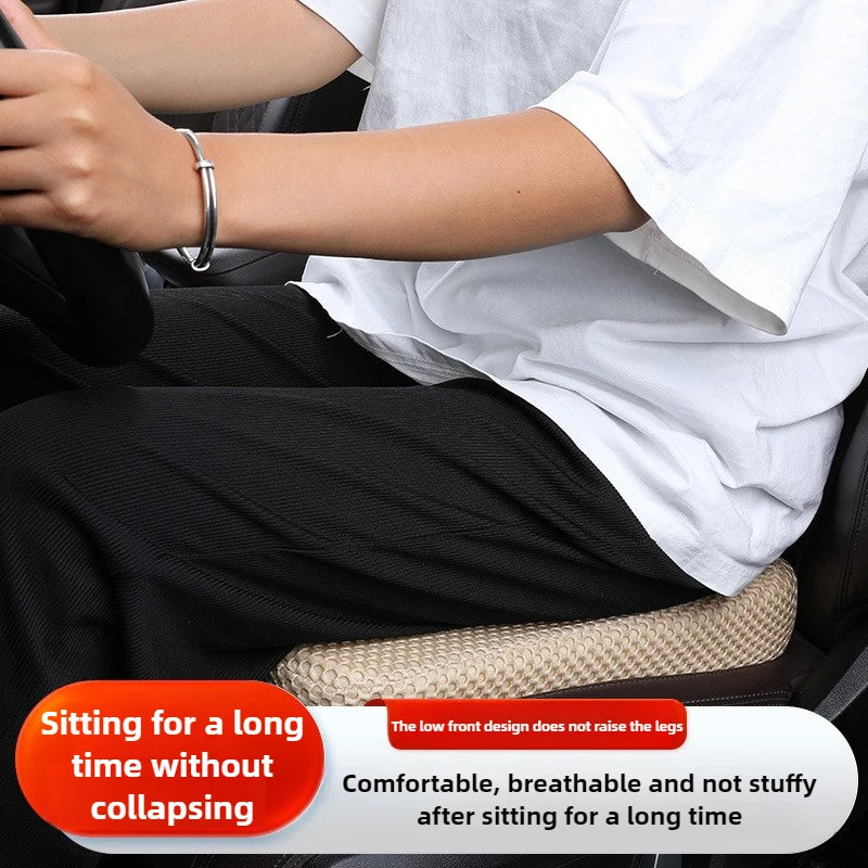 A person is sitting in a car seat with a black cushion, demonstrating comfort and support.
