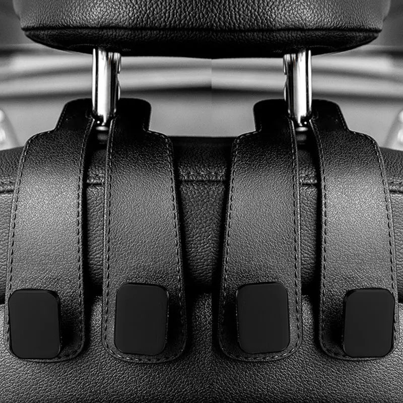 Close-up view of black car headrest hooks designed for bags and shopping organizers.
