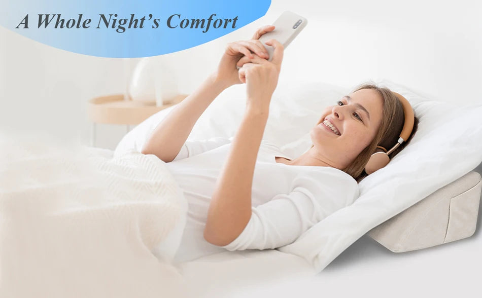 Eine Frau macht Fotos mit einem Smartphone, während sie auf einem weißen Bett mit einem Memory-Foam-Kissen entspannt.