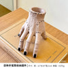 A light beige resin hand planter and pen holder with decorative stitching, shown on a wooden surface.
