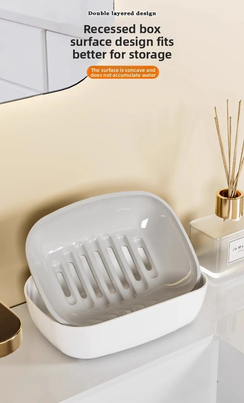 A white double-layered draining soap dish with a non-slip base shown on a countertop.
