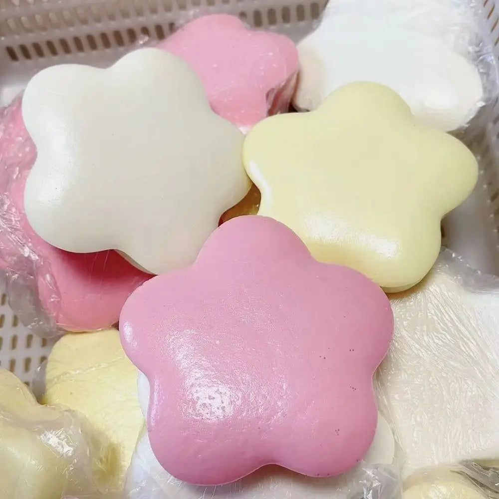 A collection of pink and white star-shaped stress relief squeeze toys in a clear plastic container.