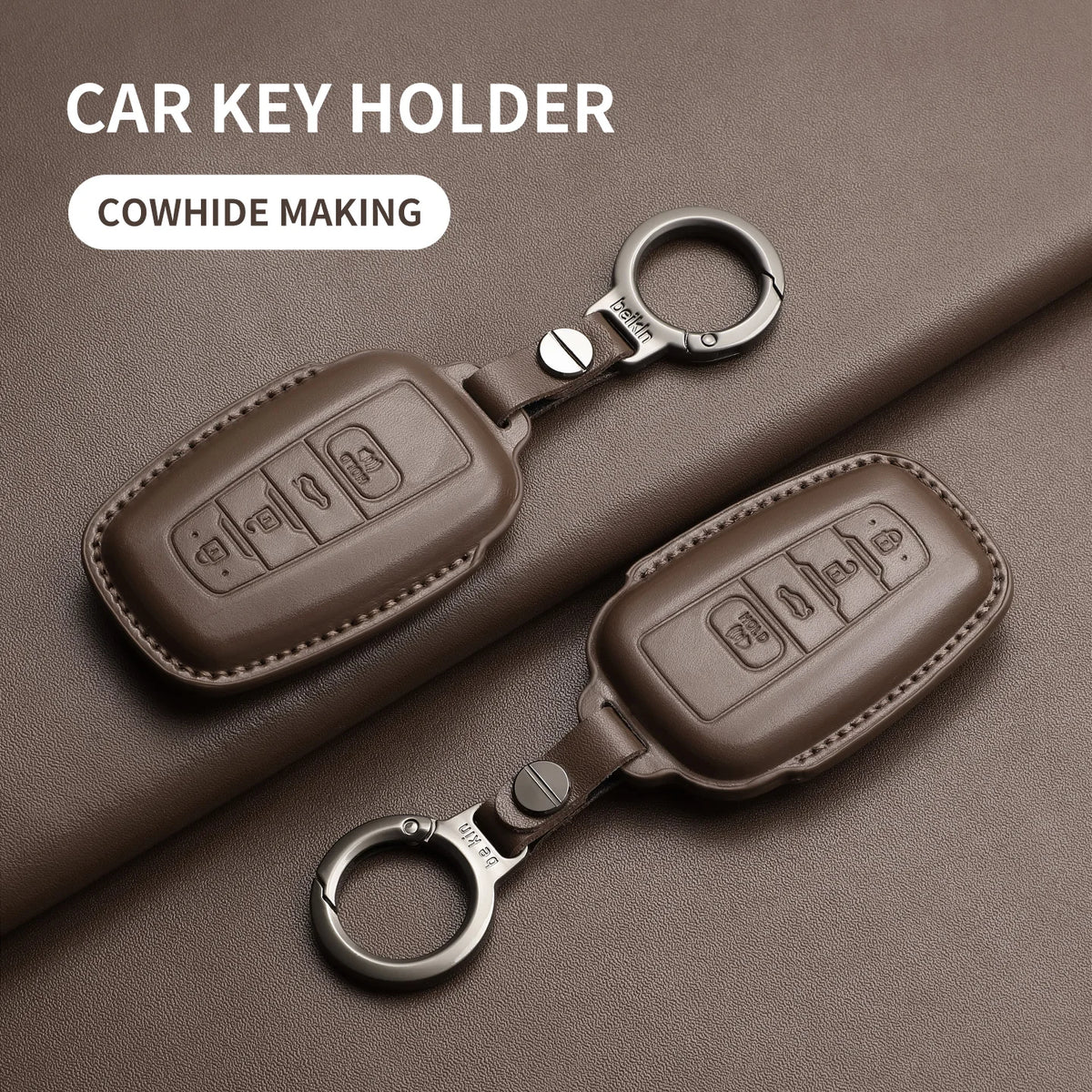Brown genuine leather car key holder with a metal ring, shown on a dark brown surface.
