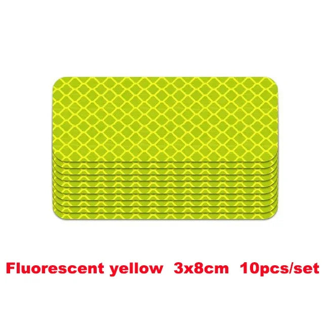 A stack of fluorescent yellow 3x8cm reflective strip stickers for car safety.