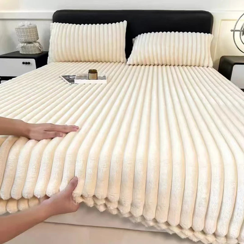 A thick, cream-colored knit fitted bed sheet with vertical ribbing is displayed on a bed.