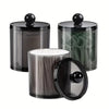 A set of clear apothecary jars with black lids for storage and organization.