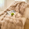 Helles beiges Kunstpelz-Fleece-Decke über einem Sofa, mit einem grünen Apfel und einer Zeitschrift sichtbar.
