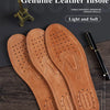 Three genuine leather insoles for men in a tan brown color displayed on a dark wooden surface.