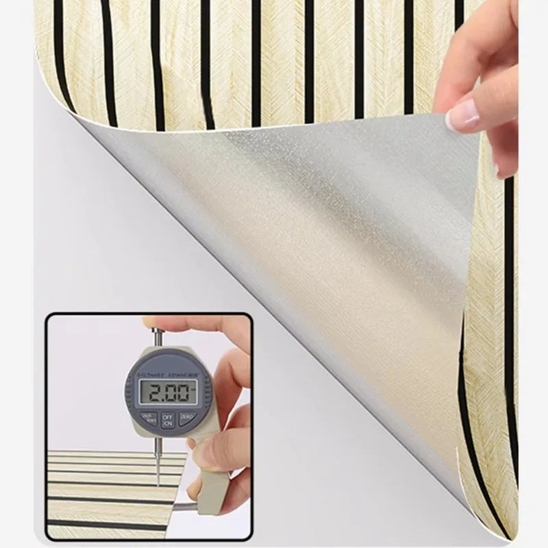 A hand is holding a self-adhesive wood grain wall panel featuring vertical stripes in beige and black.