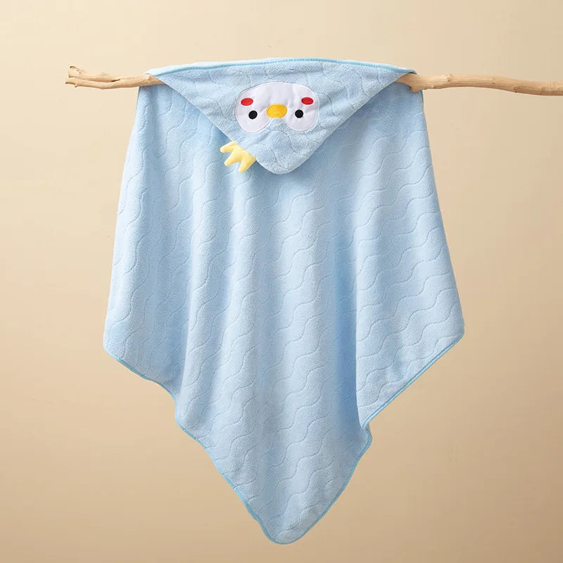 Light blue hooded baby bathrobe towel with a yellow cartoon owl design hanging on a wooden branch