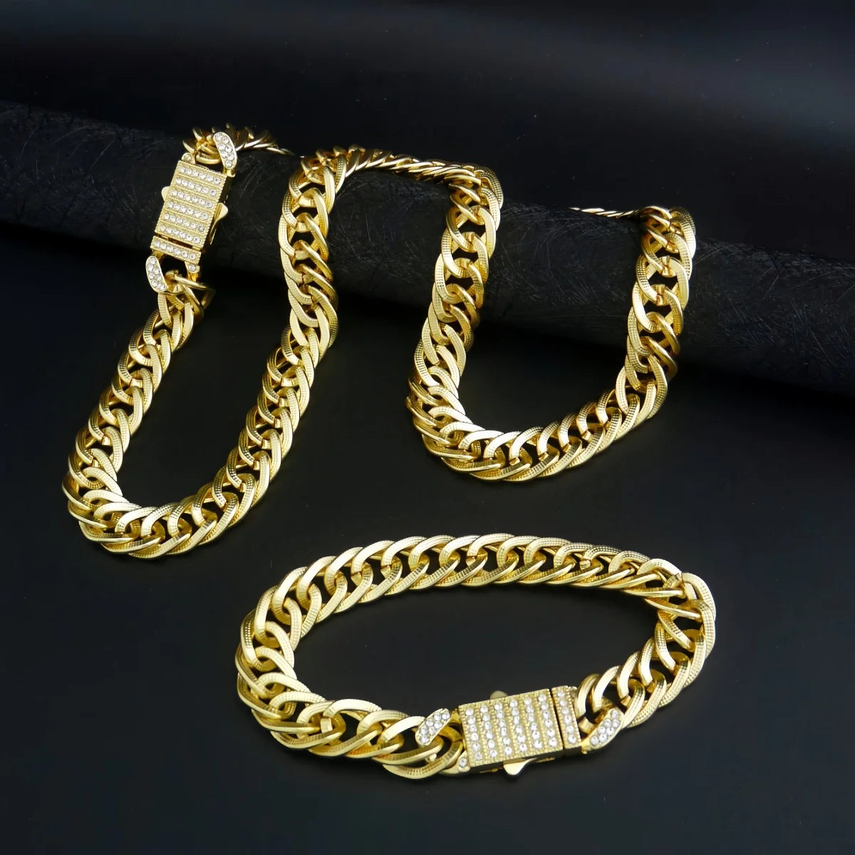 Un ensemble de bijoux en chaîne cubaine plaquée or, avec une chaîne à maillons épais et un pendentif assorti.