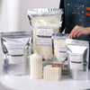 Packaged natural soybean wax flakes and a finished candle in a white holder.