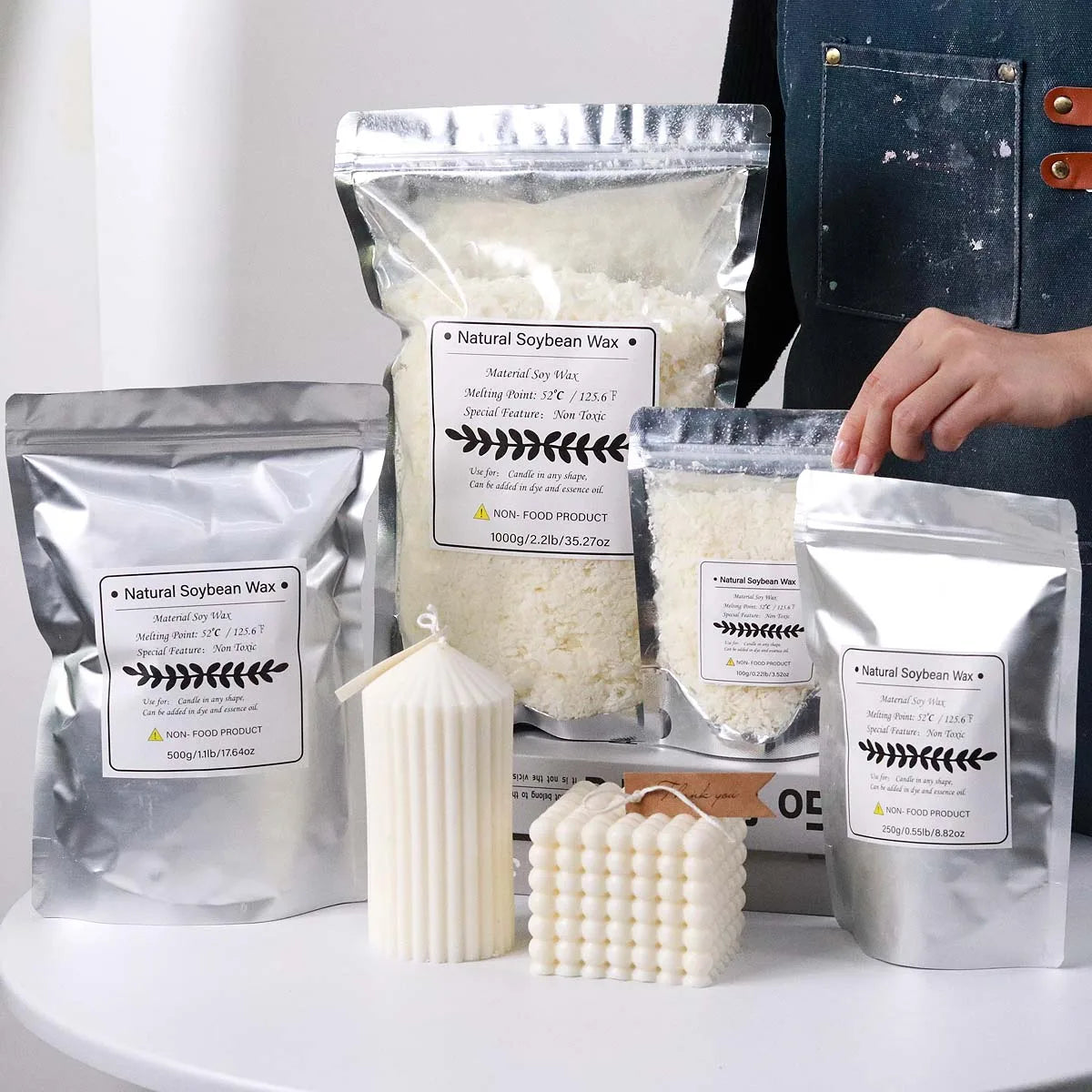 Packaged natural soybean wax flakes and a finished candle in a white holder.