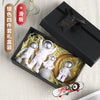 A black box contains a set of white astronaut figurines and natural straw material for desk decor.
