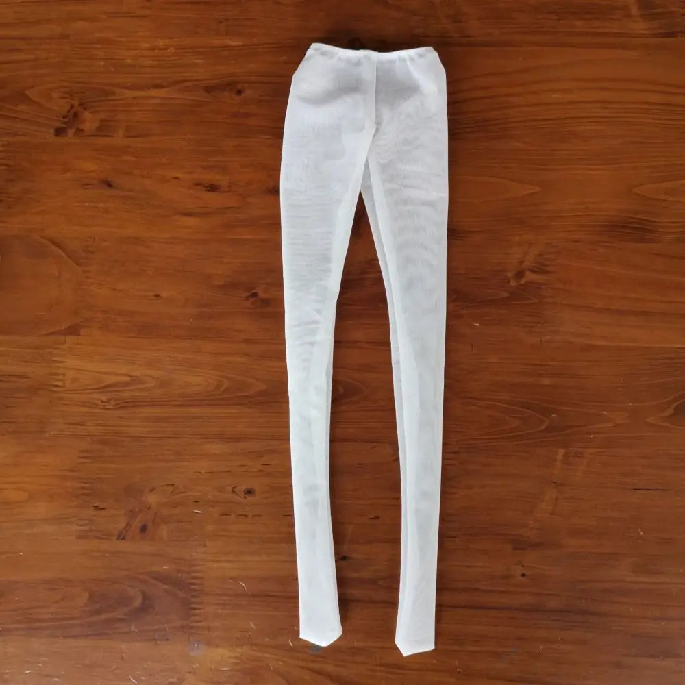 White sheer stockings or tights laid flat on a wooden surface.