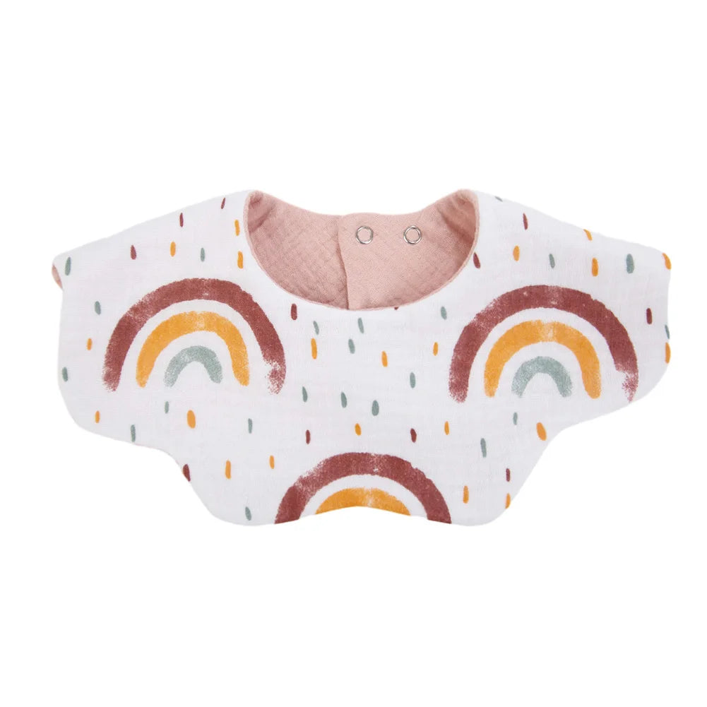 A white baby bib made of muslin cotton featuring a rainbow pattern in brown, yellow, and green colors.