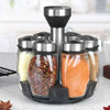 A set of rotating glass spice jars with a black rack for storage and display.