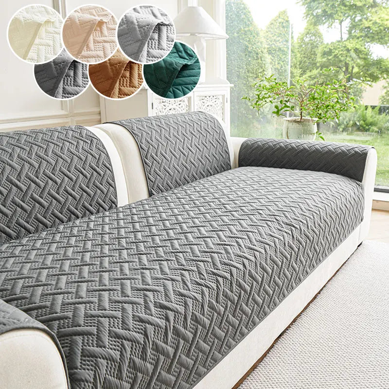 A gray quilted anti-slip sofa cushion displayed on a white sofa with decorative fabric swatches.