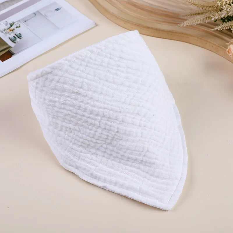 A white, quilted baby bib is shown on a light background.