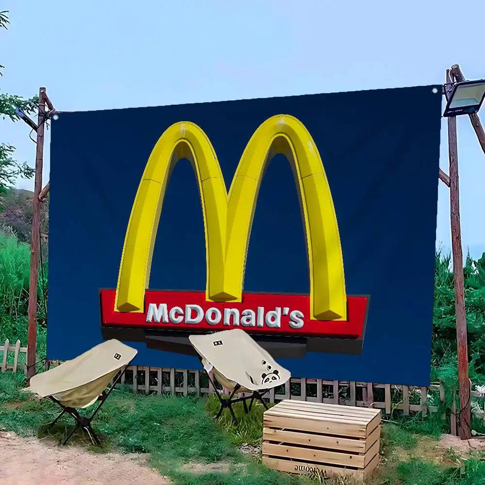 Grande bannière bleue avec le logo McDonald's, installée à l'extérieur avec des supports en bois.
