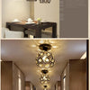 A crystal single-head ceiling lamp with a metal frame is shown hanging in a modern interior setting.