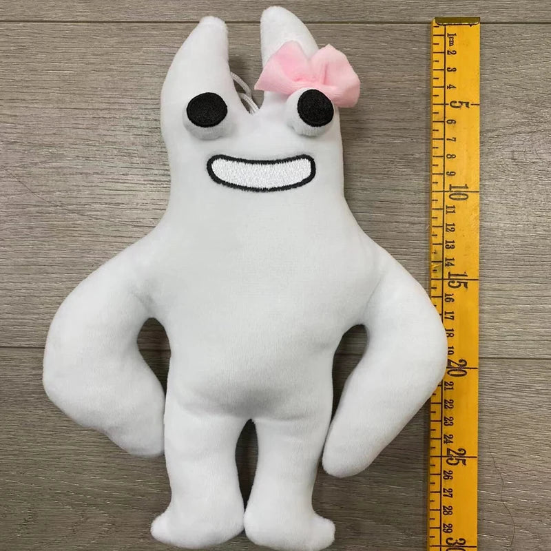 A white plush toy resembling a bird with large eyes and a pink bow.