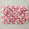 A dense wall panel composed of pink and white silk rose flowers for weddings and events.