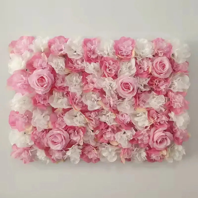 A dense wall panel composed of pink and white silk rose flowers for weddings and events.