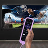 A hand holds a purple glow-in-the-dark silicone remote control cover, positioned in front of a television screen displaying a