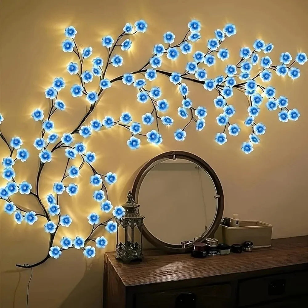 A decorative cherry blossom tree lamp with blue LED lights mounted above a wooden dresser and mirror.
