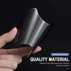 A hand holds a black carbon fiber door handle protector sticker, showcasing its texture and protective design.