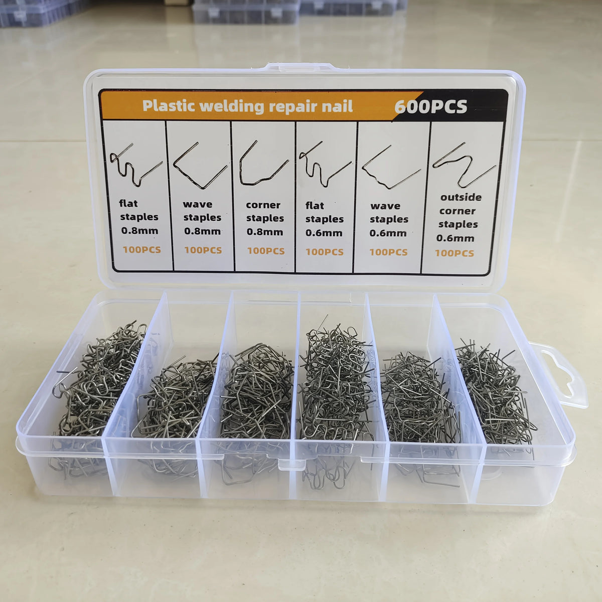 A plastic welding repair nail kit with various size and shape staples stored in a clear plastic box.