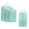 A set of light mint green compressible packing cubes for travel organization.