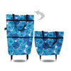 A teal blue floral patterned foldable rolling shopping bag with black handles and wheels.